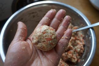 手取一些馅料，左右手之间倒几下，成乒乓球大小的肉圆，放进空气炸锅的炸篮中