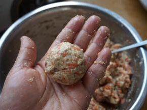 手取一些馅料，左右手之间倒几下，成乒乓球大小的肉圆，放进空气炸锅的炸篮中