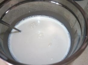 再将鲜牛奶倒入盆中，用净勺充分混合均匀；