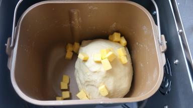 待一个揉面程序结束后，将软化的黄油入桶中，剩下的工作全部交给面包机啦