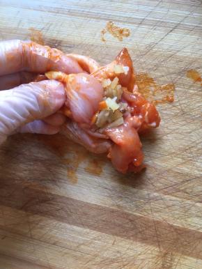 取出腌制好的鸡翅，把饭填进鸡翅里面，米饭不要塞太多，因为鸡翅在烹饪的时候会收缩，塞太满的话，鸡翅容易胀爆，塞三分之二就可以了