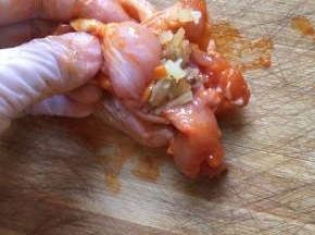 取出腌制好的鸡翅，把饭填进鸡翅里面，米饭不要塞太多，因为鸡翅在烹饪的时候会收缩，塞太满的话，鸡翅容易胀爆，塞三分之二就可以了