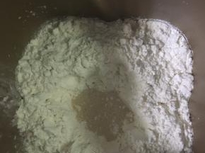 再倒入干粉（高粉和低粉），用手将粉中间挖个洞，倒入酵母。