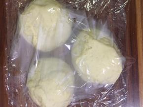 将发酵好的面团取出，排气，用力揉搓面团。将面团均匀地分为三等分，用手搓成圆形，盖上保鲜膜，静止15分钟。