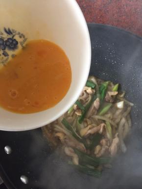 在锅中央倒入适量鸡蛋液