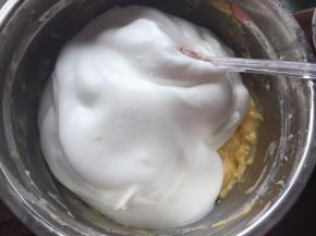 取1/2蛋白霜到蛋黄糊中用刮刀切拌均匀