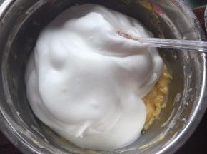 取1/2蛋白霜到蛋黄糊中用刮刀切拌均匀