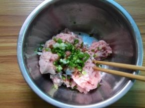 肉末里加蛋清、葱末、姜末和盐，用力搅拌均匀上劲