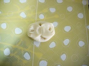 取一块松弛好的面团先用拇指在中间压一下，两边的位置对夹起来