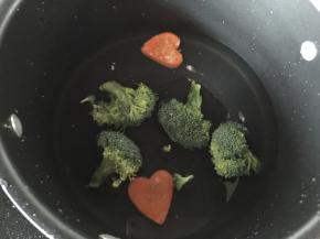 锅里烧开水后将胡萝卜、西兰花加盐和油焯熟