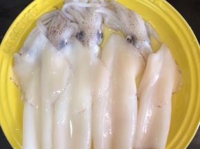 先来处理鲜鱿，把鲜鱿里面的东西全部掏干净，表面的皮也脱下来，