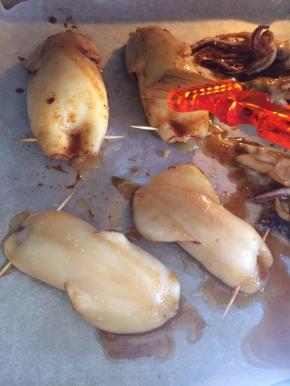 烤盘上铺锡纸，（家里没有锡纸了我用油纸代替）把塞满土豆泥的鱿鱼放在烤盘上，再刷上一层腌制用的酱