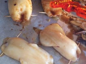 烤盘上铺锡纸，（家里没有锡纸了我用油纸代替）把塞满土豆泥的鱿鱼放在烤盘上，再刷上一层腌制用的酱