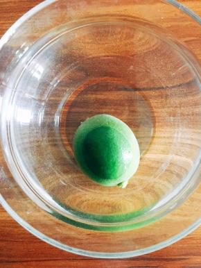 因为夹心的青柠凝酪是熬制的，使用时需要冷却。所以先进行制作。配制适量小苏打水，将青柠泡一会儿。