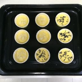 在杯子蛋糕糊面上撒上些许黑芝麻或杏仁片。