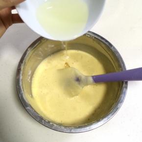 在拌好的面糊里分两次加入玉米油，翻拌均匀。