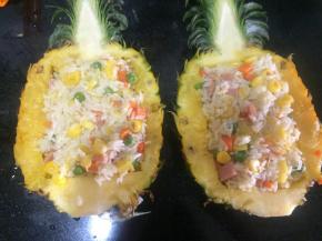 把米饭炒至和所有材料都混合均匀了，放盐调好味后把米饭盛到事先准备好的菠萝里