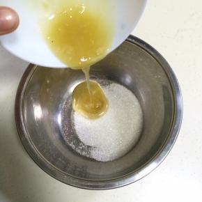 在打蛋器盆内加入细砂糖和蜂蜜。