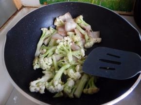 炒匀后加入五花肉不停的炒