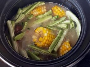 汤汁呈白色，玉米和腊肉的精华都熬了下来，尝一下豆角，熟了就可以尝味关火了。