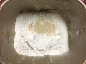 牛奶，面粉和酵母放入面包机桶里，揉面程序15分钟，到达光滑，盖上保鲜膜静止