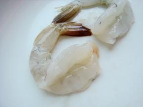 剥掉虾皮（如图要留尾）用刀在虾的背面划开一些，清洗干净。