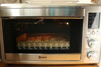 烤盘放入东菱电子岩烤烤箱，选择披萨程序，开始烤制。