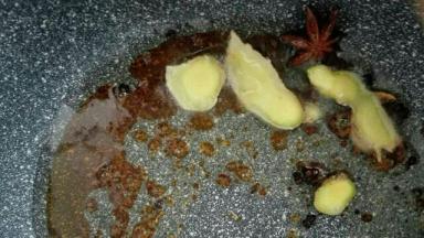 3，冰糖全部融化，颜色微黄，冒小泡泡时，下入八角、桂皮、葱、姜稍翻炒，然后放入鸡胗翻炒上色