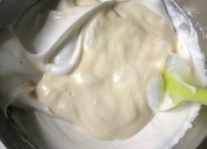 预热烤箱160度上下火。烤箱中层，放入烤盘，里面放温水。挖取三分之一蛋白霜加入到酸奶面糊中，拌匀。