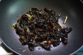 放入木耳煸炒，调入酱油、料酒、醋炒匀
