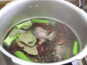 高压锅加水，加肘子，再放姜、花椒、干海椒、八角、三奈、草果、大葱、料酒、姜，加入老抽