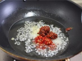锅里入油，加入姜片、蒜、放豆瓣、泡椒炒香
