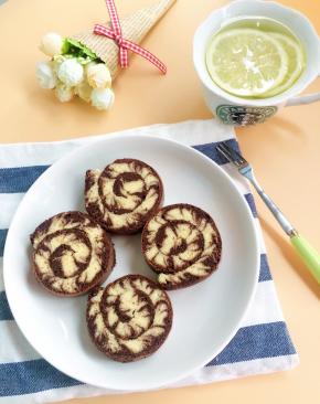 放至表面不烫手后倒扣撒开油纸，卷的时候要平行最后一次画的纹路来卷，另外喜欢加奶油一起卷的可以打发100克淡奶油当夹馅一起卷