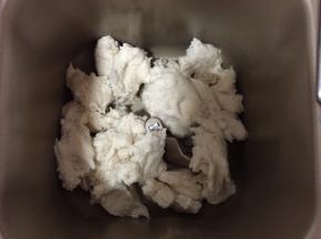 把发酵好的中种面团撕成小块放进面包桶里