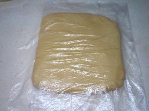 取一张保鲜膜，其实用一个保鲜袋剪开更好用噢；将面团放在保鲜膜中间，手按压平整，入冰箱冷藏保存至少30分钟后再用；