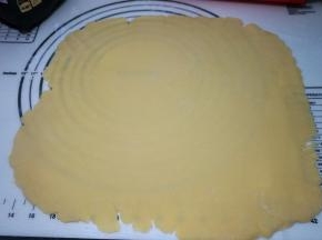 冷藏好的面团取出，放在揉面垫上，撒高筋面粉防粘，高筋面粉入烤箱烘烤后不会变色，用低粉容易变黑；擀成厚约3、4毫米的薄片；