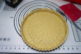 将面皮轻放在派盘上，用手按压面皮，使之服贴在派盘上，将边边角角的面皮均匀地补在各处，全部用完；用餐叉扎出洞洞，防止烤的时候变形；