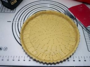 将面皮轻放在派盘上，用手按压面皮，使之服贴在派盘上，将边边角角的面皮均匀地补在各处，全部用完；用餐叉扎出洞洞，防止烤的时候变形；