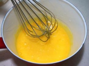 蛋黄、细砂糖同入奶锅中，搅拌均匀；