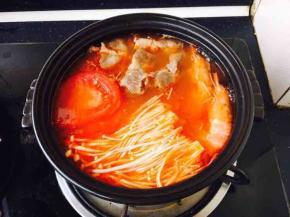 取一只砂锅，放在炉灶上，盛入适量的番茄汤，煮开，然后放入提前处理好的金针菇、肥牛、番茄片、鲜虾，放入少许盐调味，出锅后放入自己喜欢的青菜。