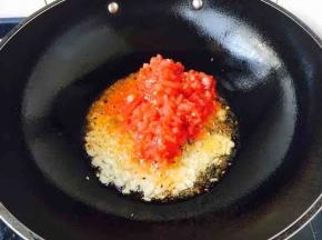 锅里放适量的油，小火炒香洋葱末和蒜末，然后放入步骤4准备好的番茄丁，改中火煸炒。