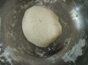 盘里倒入300克面粉，加入半匙盐，一边倒水一边用筷子拌成絮状，揉成光滑面团