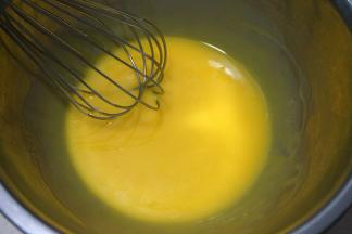 蛋黄中加入40克玉米油，用手动打蛋器混合均匀