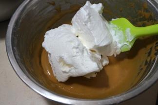 将三分之一蛋白糊入蛋黄糊中，用硅胶刮刀从下向上翻拌均匀