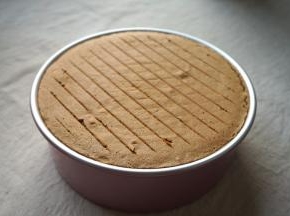 蛋糕回落，与模具持平，出炉，立即端起模具轻轻震几下，将蛋糕内部多余的热气震出，然后倒扣在晾架上；晾的过程中还可以调换一下位置，防止蛋糕表皮嵌入到晾架里