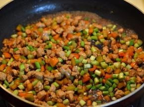 倒酱油调色，将蒜薹和辣椒丁入锅中翻炒几下，撒适量盐，倒足够量的开水，煮开