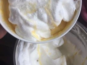 然后取1/2蛋白霜到蛋黄糊中用刮刀切拌均匀