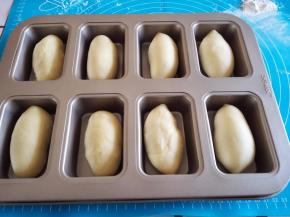 用擀面杖排气，擀卷成长条形放入模具里面。