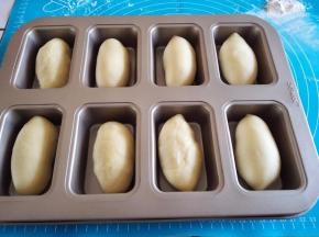 用擀面杖排气，擀卷成长条形放入模具里面。
