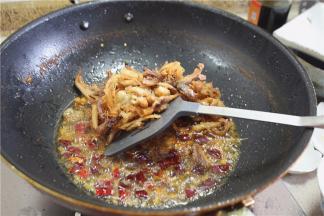 下入炸好的鸡肉，与香料混合，干煸入味